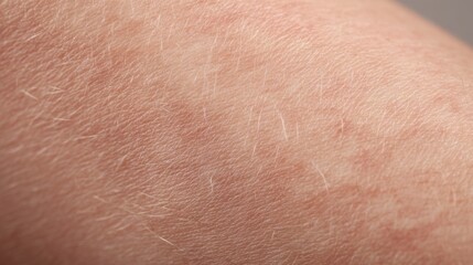 Fototapeta premium Close-up of fair skin exhibiting fine lines, subtle discoloration, and light hair follicles. The texture appears smooth yet slightly uneven