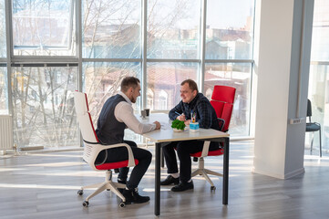 Two Caucasian men communicating at a business meeting. 