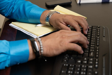 Male masculine hands type on the office keyboard entering data for the company
