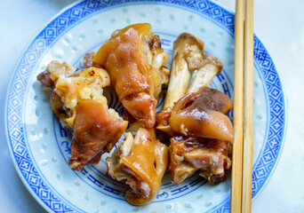 Chinese braised pig trotters on plate with chopsticks aside.