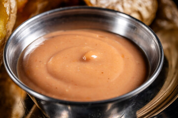 Spicy creamy sauce in metal bowl close-up