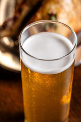Cold kolsch beer with foam head on wooden table