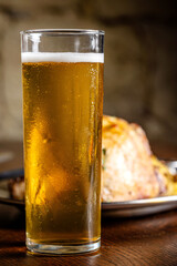 Cold kolsch beer in tall glass on wooden table