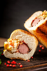 Hot dog in crusty bread with coleslaw and corn