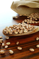 Spoon of carioca beans on the rustic table. Brazilian grain