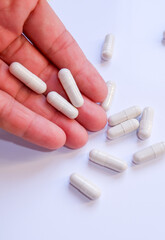 Hand Holding Medicine Capsules Close Up. White background 