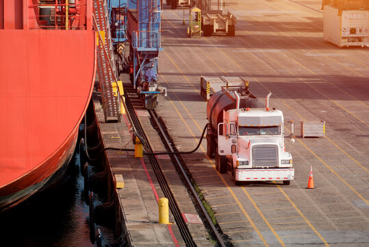 Bunkering Operation: Fuel Tanker Truck Refueling Commercial Vessel at Port Terminal