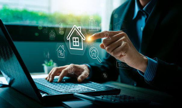 Real estate investment and property business concept with businessman using laptop and touching digital house icon hologram showing sale, rent, mortgage, and smart technology solutions - Powered by Adobe