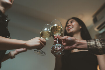Friends toasting white wine glasses celebrating success
