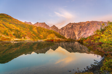 夜明けの八方池に映る紅葉の白馬三山