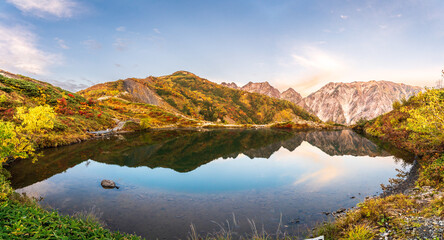 夜明けの八方池に映る紅葉の白馬三山