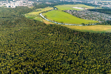 Dense green forest canopy from above, showing a lush, vibrant natural landscape. A winding river...