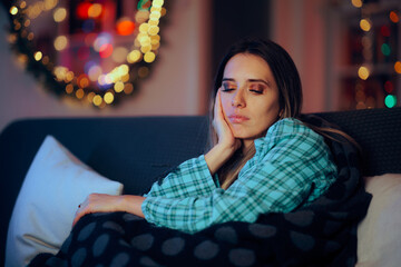 Sad Woman Spending the Holidays Alone on her Couch. Unhappy depressed person feeling stressed during Christmas 

