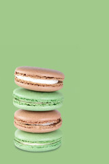 Sweet dessert composition: pastel macarons arranged in a vertical stack.