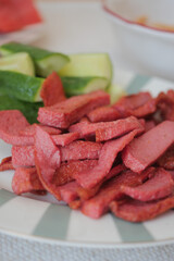 Delicious sliced meat with fresh cucumber on a plate