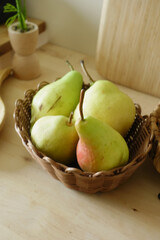 Fresh pears arranged in a wicker basket on a table