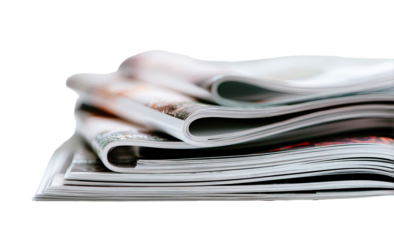 Stack of magazines, various pages visible, soft focus