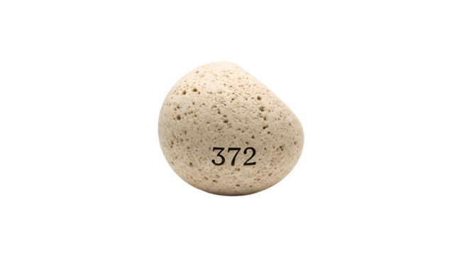 Porous light beige stone with number "372" on black background