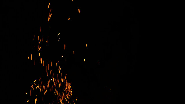 sparks and embers from campfire flying over black background - Powered by Adobe