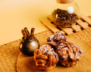 Delicious cinnamon rolls with coffee beans on a wooden table in a cozy setting