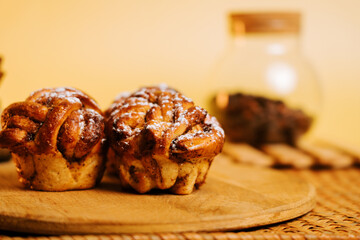 Freshly baked cinnamon rolls served on a wooden board with warm lighting in the background