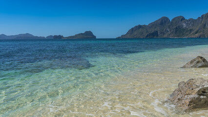 Beautiful seascape. The sandy bottom is visible through the clear turquoise ocean water. Boulders...
