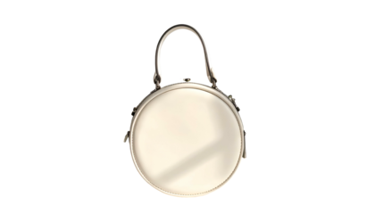 Round, cream-colored purse with metallic handle against black ground