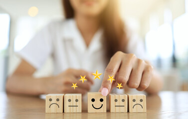 customer satisfaction concept with woman hand chosen smile wooden block represent to very satisfied in service and products