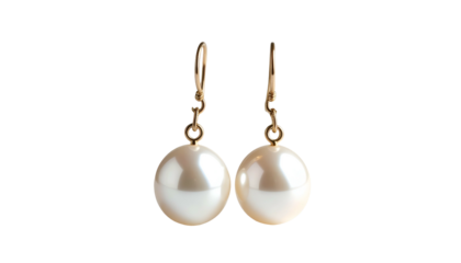 Pearl drop earrings with gold hooks against a black backdrop