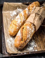 Two Golden Baguettes on Parchment Paper in a Tray