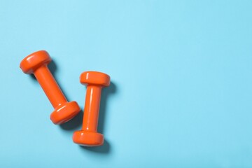dumbbell and a rubber band on a blue background. top view. flat lay. fitness equipment.