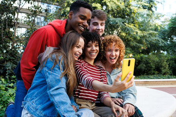 Fototapeta premium Happy students taking a selfie with smartphone outdoors