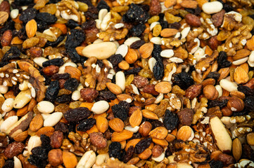 Pile of nuts and dried fruit for a snack. Bulk snacks at the store for a healthy and nutritious meal, close-up as a background