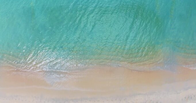 Beautiful beach summer landscape, Waves sea water surface High quality video Bird's eye view, Drone top view waves crashing on sand beach,Nature ocean sea beach background