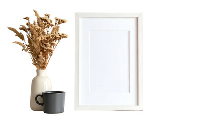 Composition featuring a blank white picture frame, vase with dried flowers, and a mug