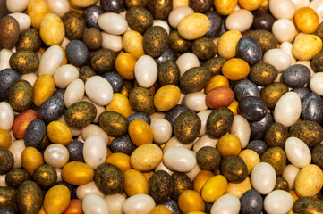 Pile of colorful glazed dragees. Shiny candies in a sugar crust. A background of glazed or chocolate-covered nuts