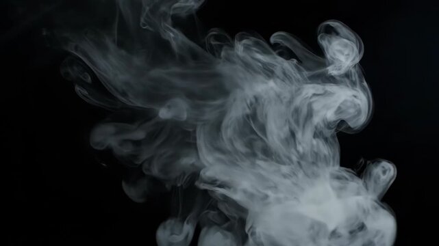 Billowing white smoke creates an ethereal abstract pattern against a dark black background.
