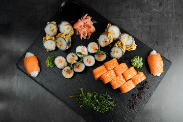 Sushi rolls with salmon and avocado on slate board