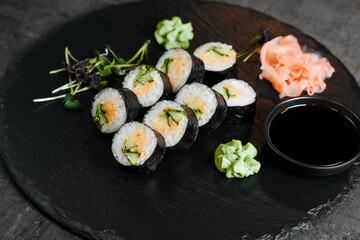 Sushi set with ginger wasabi and soy sauce on slate board