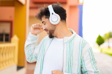 Handsome Arab man at outdoors listening music and dancing