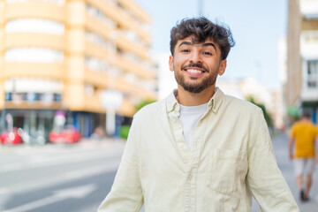 Young Arabian handsome man at outdoors smiling