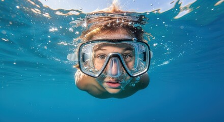 Naklejka premium Young female swimmer underwater wearing snorkel mask in clear blue ocean