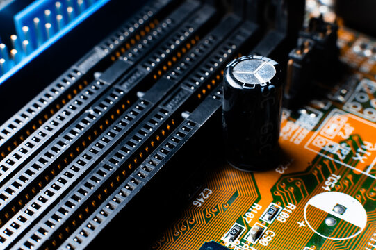 The reverse side of the microboard on a orange background. Electronic board with electrical components, computer equipment. High quality photo