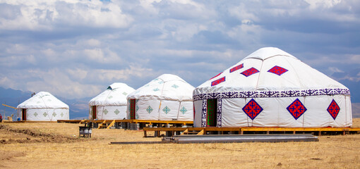 Yurt. National ancient dwelling of the peoples of Kazakhstan and Asian countries. National dwelling. Yurts against the backdrop of green meadows and highlands. Yurt camp for tourists in the mountains.