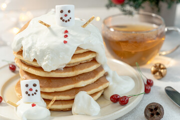 スノーマンの積み重なったパンケーキと紅茶