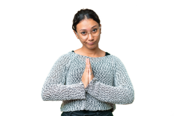 Young Uruguayan woman over isolated chroma key background keeps palm together. Person asks for something