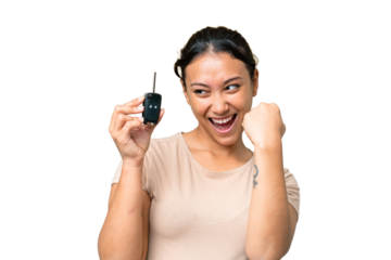 Young Uruguayan woman holding car keys over isolated chroma key background celebrating a victory