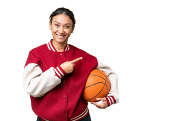 Young Uruguayan woman playing basketball over isolated wall  over isolated chroma key background pointing to the side to present a product