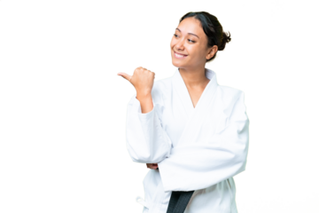 Young Uruguayan woman doing karate over isolated chroma key background pointing to the side to present a product