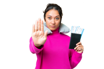Young Uruguayan woman holding a passport over isolated chroma key background making stop gesture